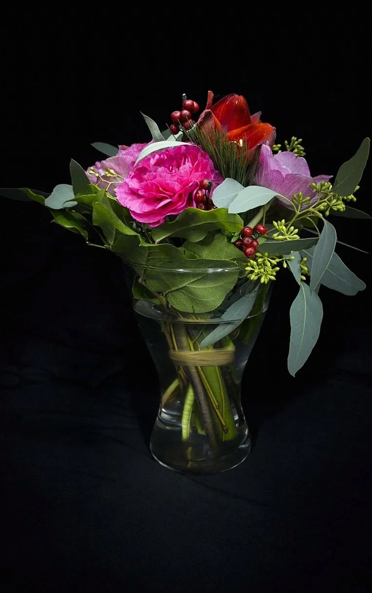 黒い背景に浮かぶピンクのバラの花束
